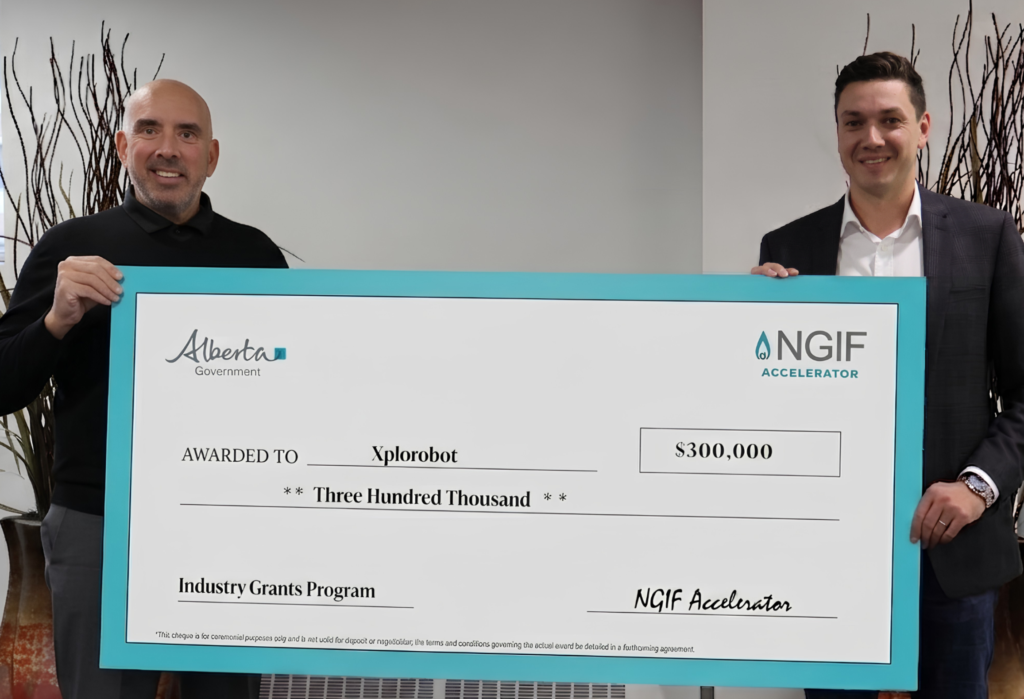 John Adams and Dan Blattler holding a big cheque.